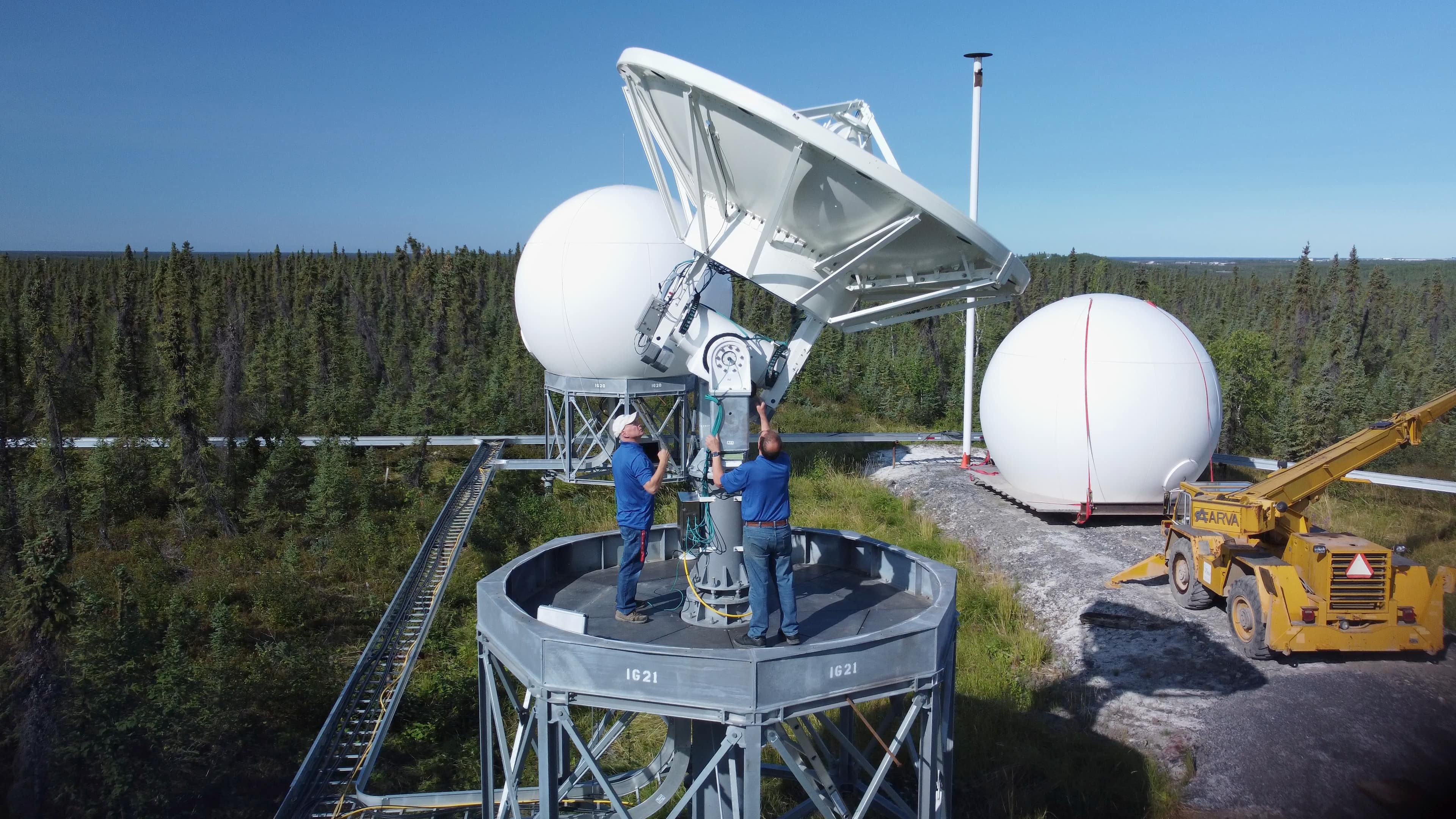 Workers making adjustments at the Canadian Satellite Ground Station in Inuvik, Northwest Territories
